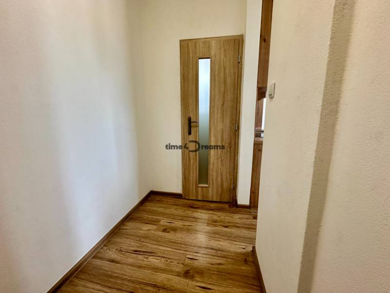 Garzonlakás fa dekor padlóval és üvegezett ajtóval.