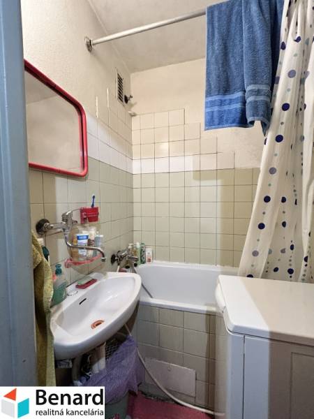Fürdőszoba a háromszobás lakásban káddal, mosdóval és mosógéppel.