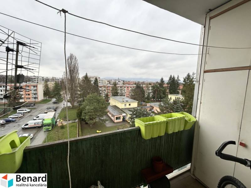 Kilátás egy háromszobás lakás erkélyéről az Október utcában, Eperjesen, parkoló és zöldterület.