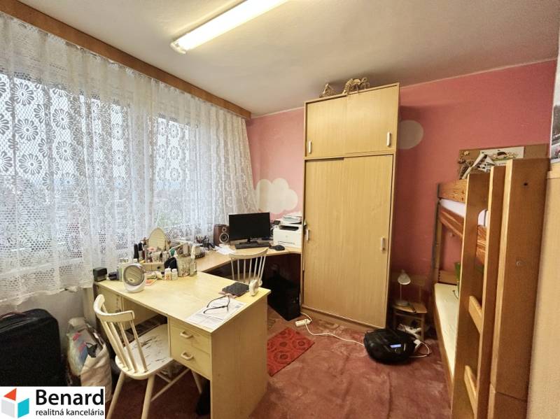 Egy emeletes ággyal és íróasztallal ellátott szoba egy háromszobás lakásban.