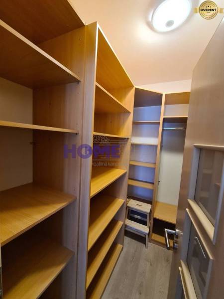 Tárolóhely polcokkal egy kétszobás lakásban, fa dekor padlóval.