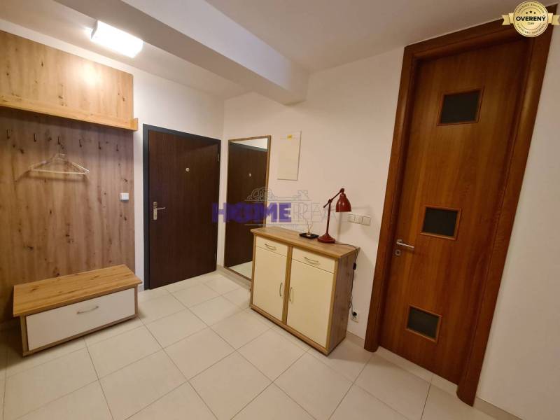 Előszoba kétszobás lakásban cipősszekrénnyel és fa dekorációs fogasfallal.