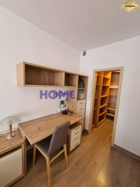 Íróasztal tárolóhelyekkel egy kétszobás lakásban, fa dekor padlóval.