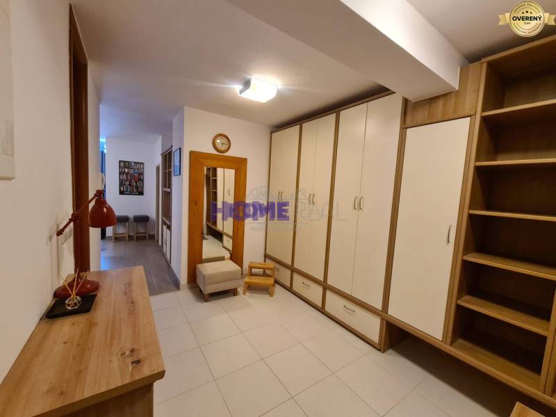 Folyosó tárolószekrényekkel és fa dekorációval egy kétszobás lakásban.