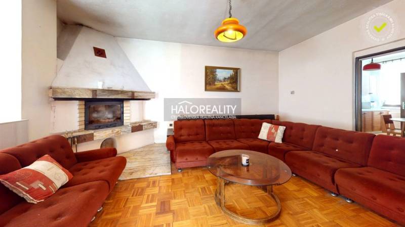 Nappali kandallóval és kanapéval egy családi házban, fa dekorációjú padlóval.