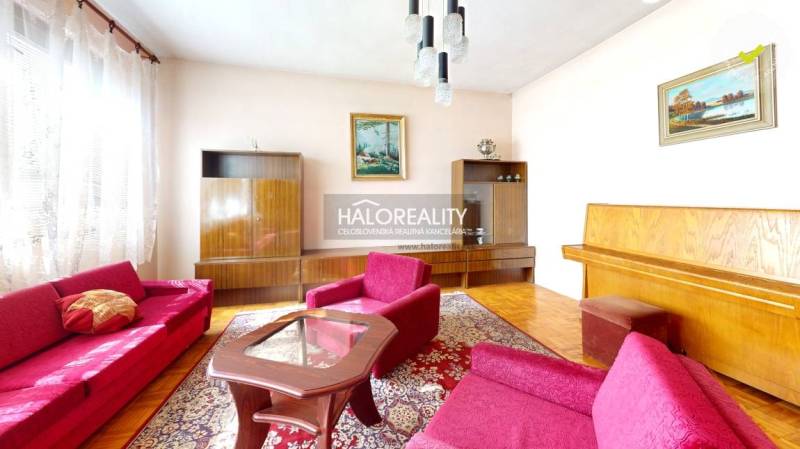 Nappali egy családi házban szőnyegmintával és fa dekorációjú padlóval.