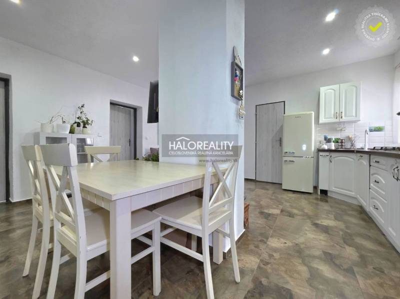 Konyha családi házban fa dekor padlóval és fehér bútorokkal.