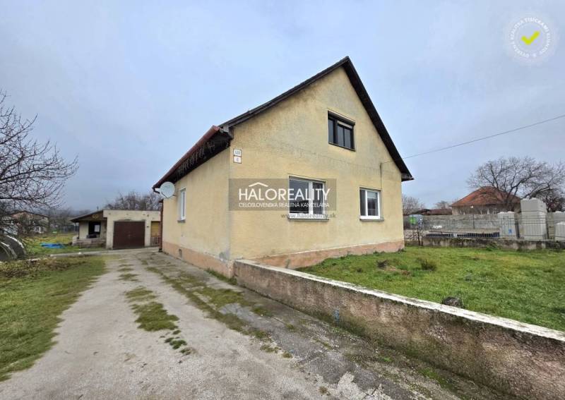 Családi ház Cseregyánban garázzsal, zöld gyepfelülettel és felhajtóval.