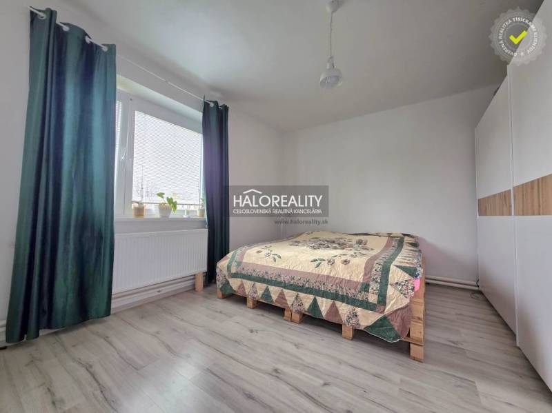 Hálószoba fa dekor padlóval, ággyal és beépített szekrénnyel egy családi házban.