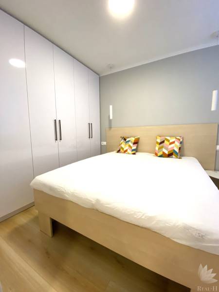 Hálószoba franciaággyal, színes párnákkal és szekrénnyel, 2 szobás lakás.