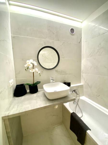 Fürdőszoba mosdókagylóval a pulton, káddal és dekorációval, 2 szobás lakás.