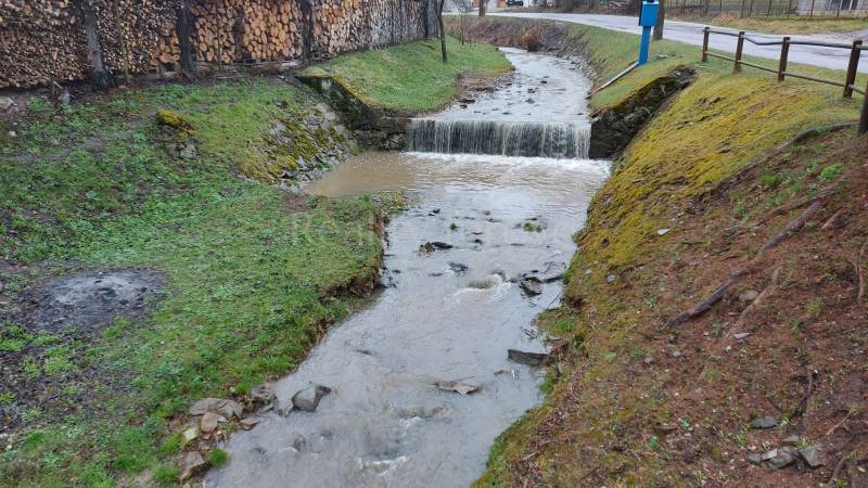 Patak, amely áthalad a puchovi üdülőterületen, a szélén tárolt fával.