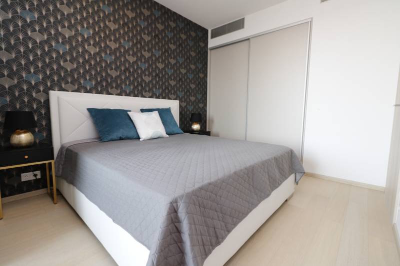 Hálószoba ággyal, mintás fal, fa dekorációjú padló, 2 szobás lakás.