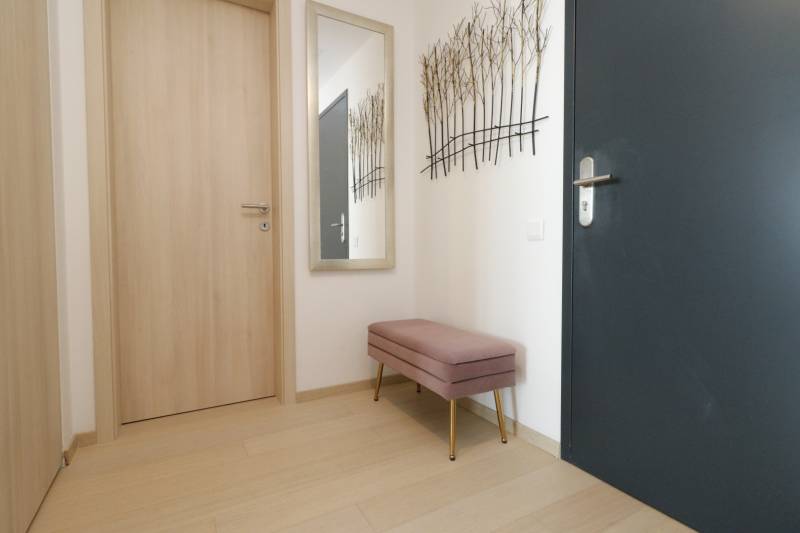 Előszoba egy kétszobás lakásban fa dekorációjú padlóval és paddal.