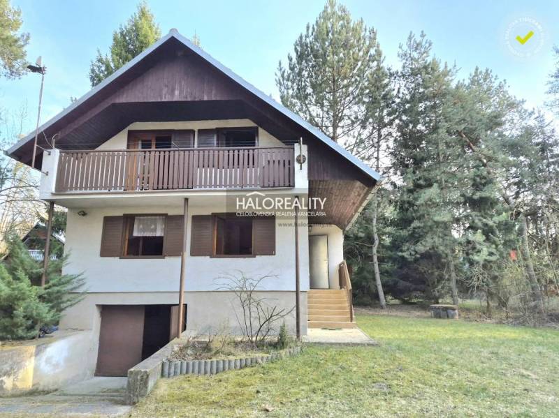 Házikó Borsky Svätý Jurban, zölddel és fákkal körülvéve, fa erkéllyel.