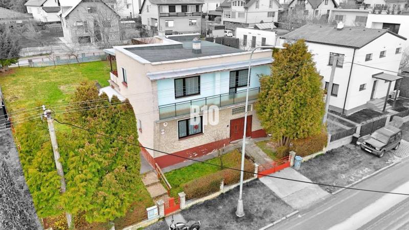 Családi ház Martinban lapos tetővel, kerttel és környező házakkal.