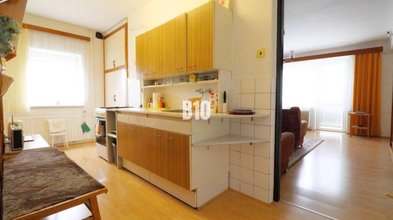 Konyha családi házban fa dekor padlóval, összekapcsolva a nappalival.