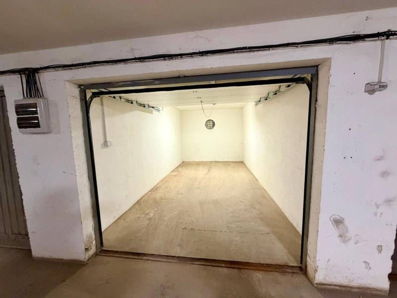 Üres garázsok betonpadlóval és egyszerű világítással.