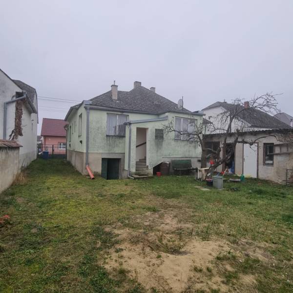 Családi ház Kisleváron kerttel és ferde tetővel.
