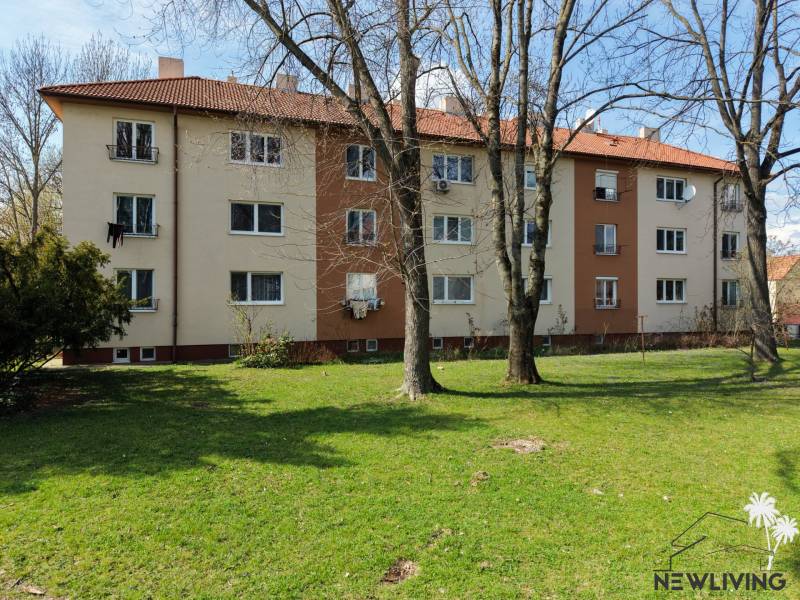 A Vajanského utcai lakóház Pöstyénben, amelyet fű és fák vesznek körül.