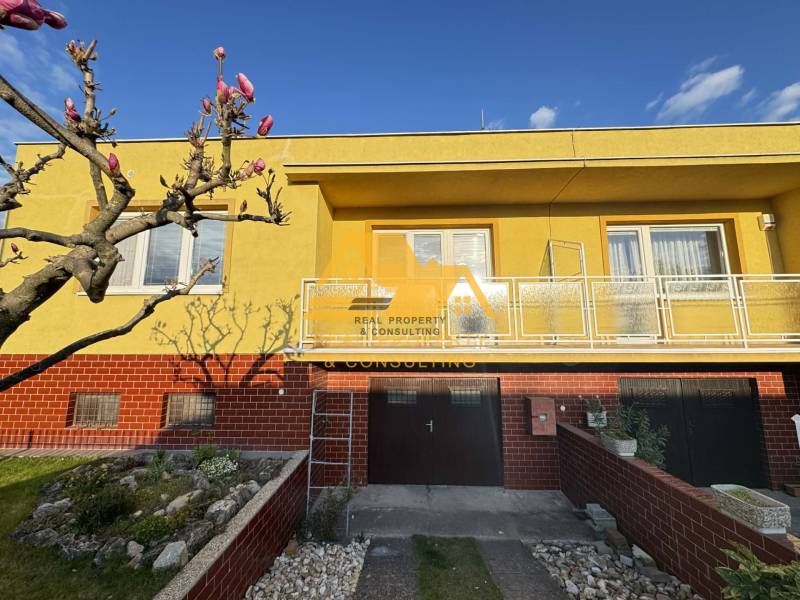 Családi ház Érsekújvár városában, Érsekújvár utcában, sárga homlokzattal és kerttel.