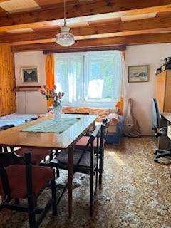 Nappali egy családi házban, étkezőasztallal és rajta virágokkal.