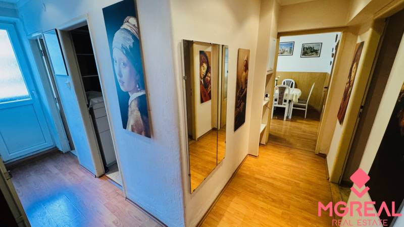 Előszoba tükörrel és fa dekorációjú padlóval egy háromszobás lakásban.