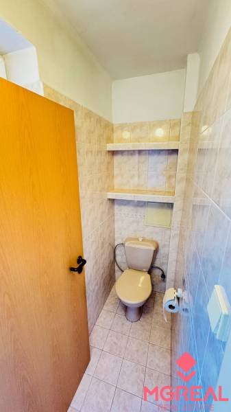 WC kerámia burkolattal és tároló polcokkal, a háromszobás lakás része.