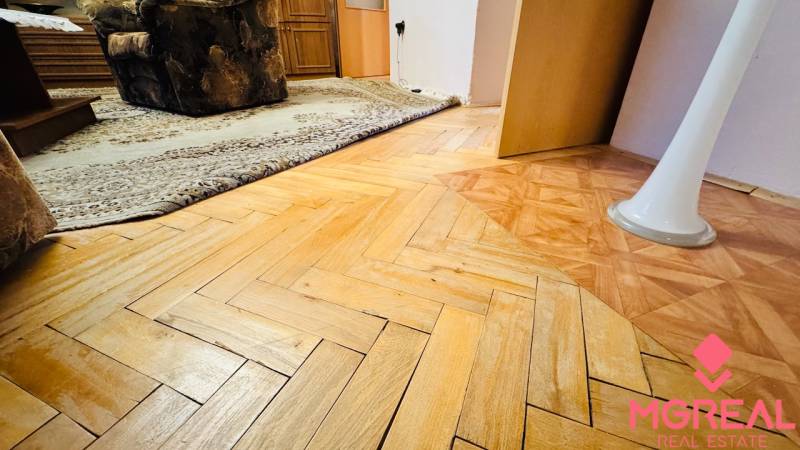 Fa dekorációjú padló a 3 szobás lakásban, szőnyeg és bútor a belső térben.