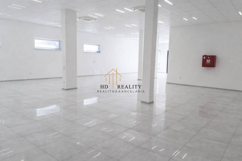 Tágas üzlethelyiségek fehér falakkal és fényes padlóval dekoratív dizájnban.