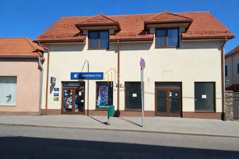 Kereskedelmi helyiségek a Krupina Obchodná utcáján ferde tetővel és kirakatokkal.