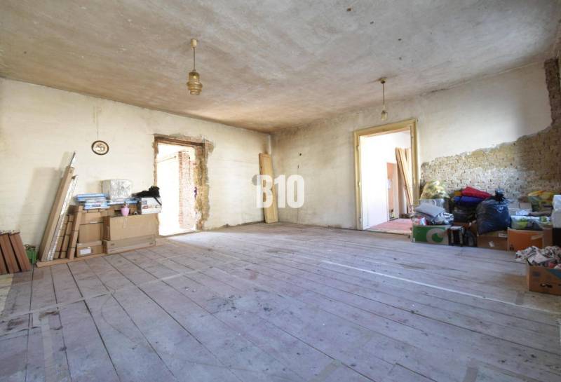 Rendetlen szoba egy családi házban, fa padlóval és építőanyaggal.