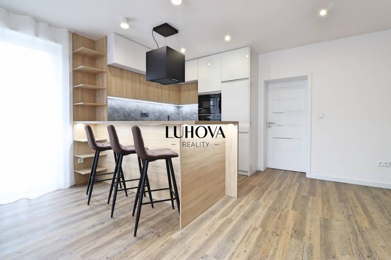 Konyha egy 3 szobás lakásban bárpulttal és fa dekoros padlóval.