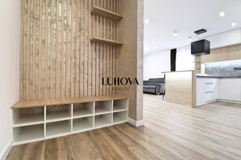 3 szobás lakás belső tere fa dekor padlóval, konyhával és nappali résszel.