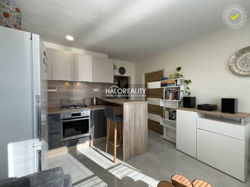 Konyha egy egyszobás lakásban világos belső térrel és ülőpulttal.