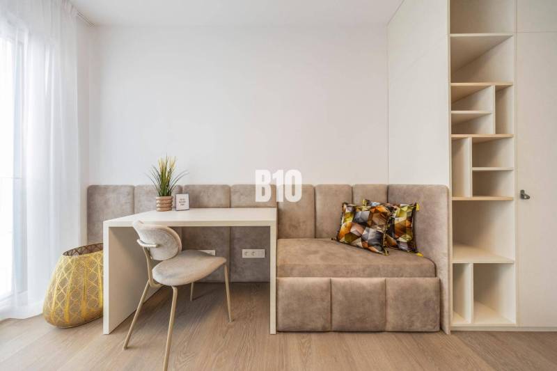 Dolgozósarok székkel, asztallal, paddal és polcokkal egy háromszobás lakásban.