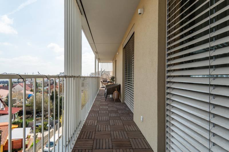 Erkély fa mintázatú padlóval egy 3 szobás lakásban, kilátással Pozsony - Ružinovra.