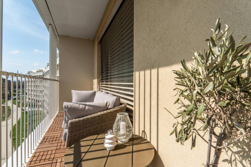 3 szobás lakás erkélye kényelmes ülőhellyel, kilátással és dekorációkkal.