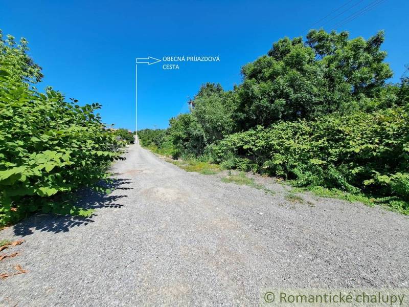 Zölddel körülvett hozzáférési út Hosťovában, alkalmas lakóterületek számára.