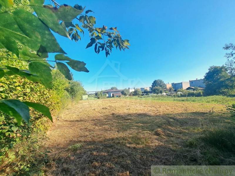 Egy nyugodt zöld telek Hosťovában, amely lakhatásra alkalmas, és amelyet természet és szomszédos házak vesznek körül.