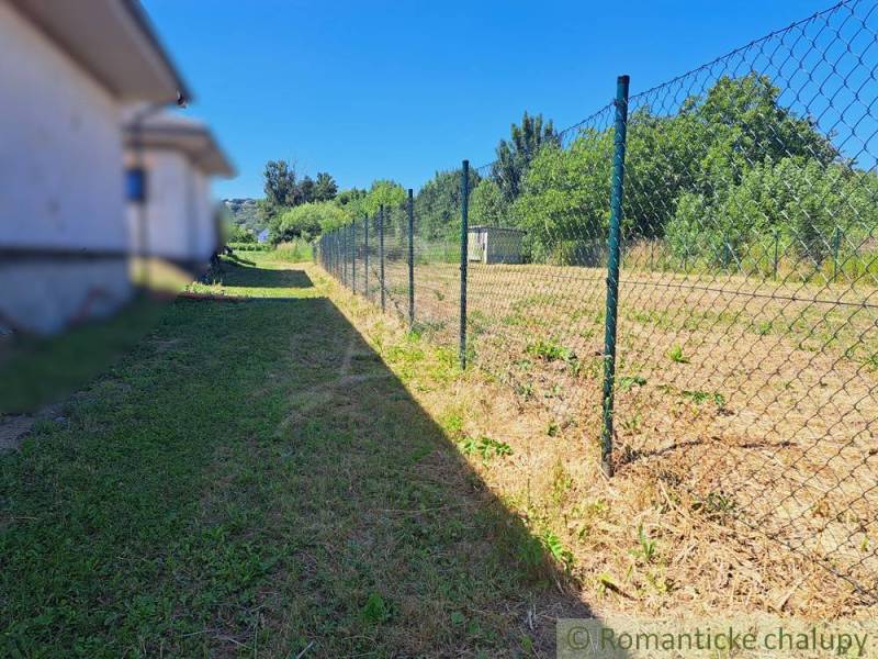 Hosťovában kerített füves telek, ideális lakhatásra.