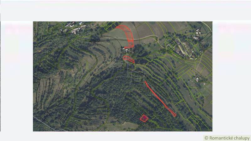 Légi felvétel a Horný Tisovníkban található lakóterületekre osztott telkekről, erdős tájjal.