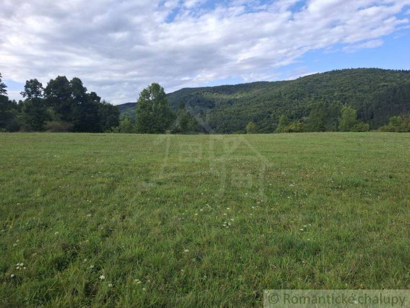 Tágas réti telkek lakhatásra Felsőtiszófaluban, erdőkkel és dombokkal körülvéve.