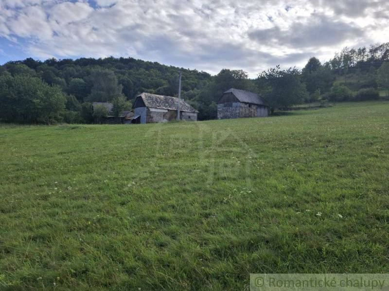 Zöld rét vidéki épülettel Felsőtisovníkban, alkalmas lakóterületnek.