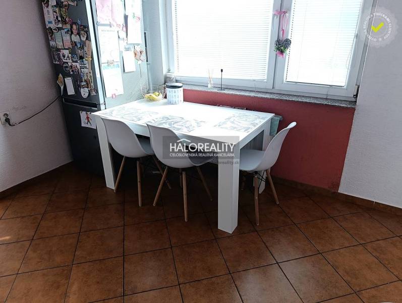 Két szobás lakás konyhája étkezőasztallal, fehér székekkel és ablakkal.