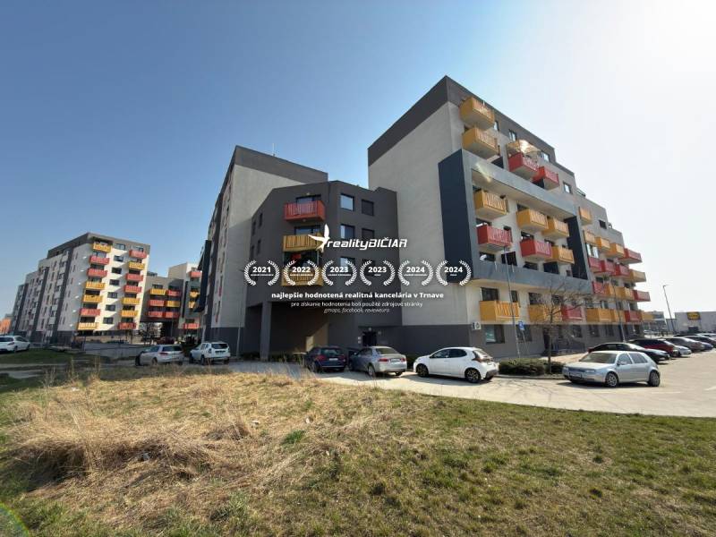 Lakóházak a Mikovíniho utcában, Nagyszombatban, parkolóval és zöld területtel.