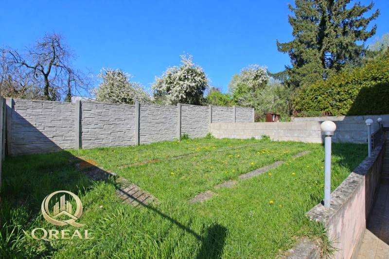 Kert a ház mellett gyepesítéssel, modern kerítéssel és világítótestekkel a Boskovičova utcában, Pozsonyban.