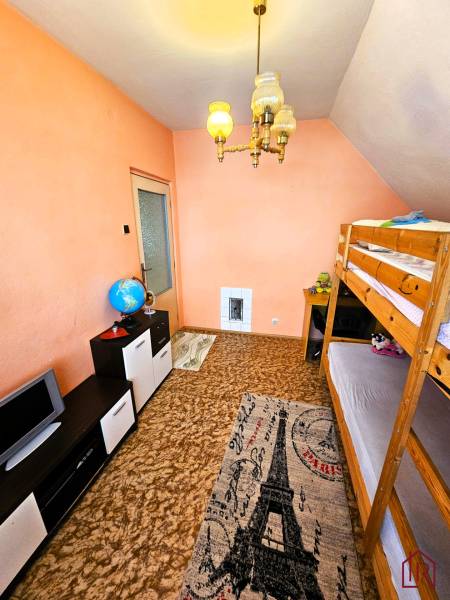 Szoba családi házban emeletes ággyal és Eiffel-tornyos szőnyeggel.