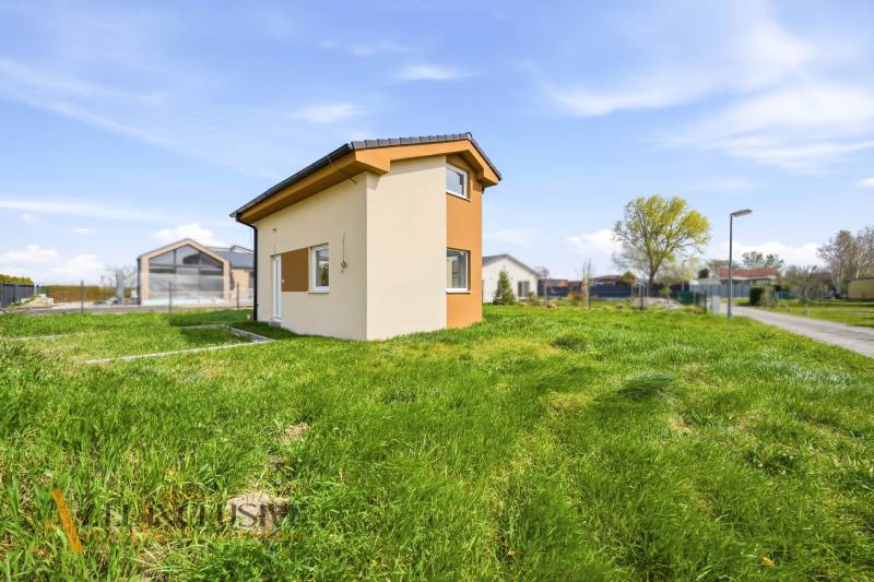 Egy ház Vojka nad Dunajom községben zöld réten áll a tiszta ég alatt.