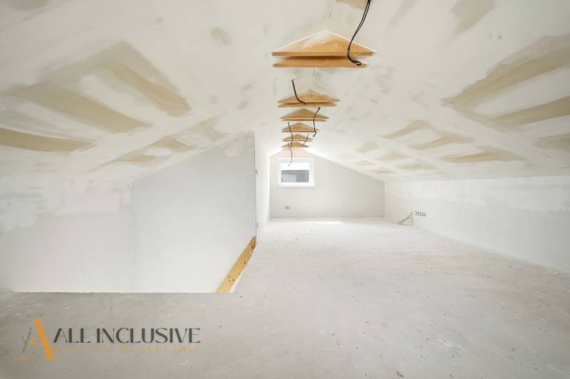 Padlástér egy fehér falú és gipszkarton mennyezetű házikóban.